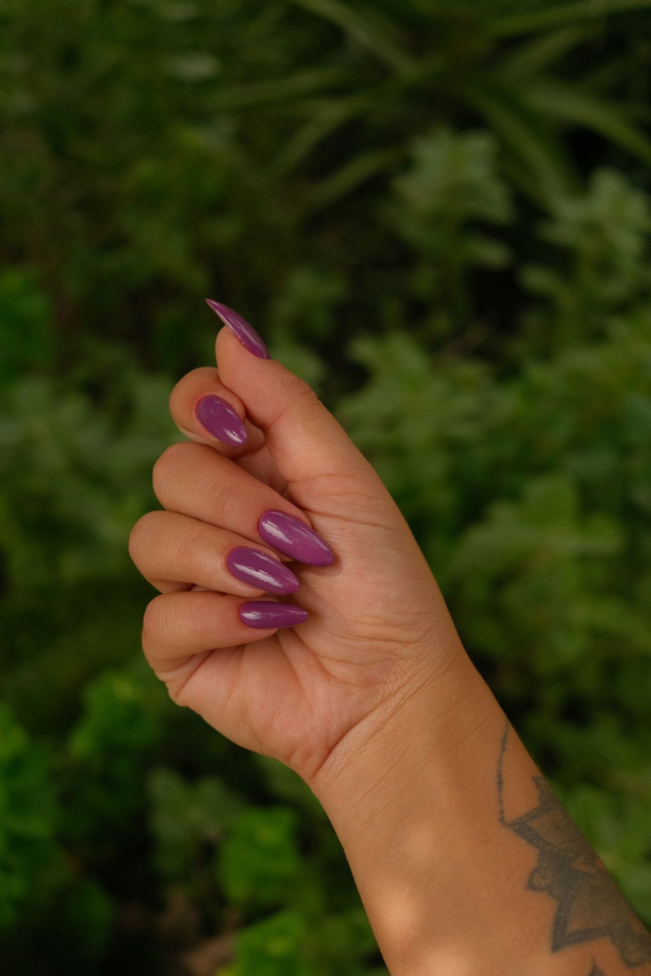 A hand displays painted purple nails.